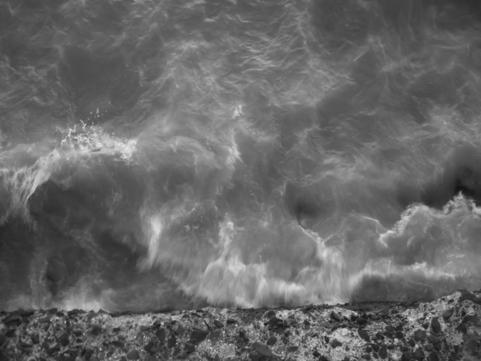 Black and white photograph of turbulent waves crashing against a rocky shoreline. The photographer titled it “Worli Sea Face”.