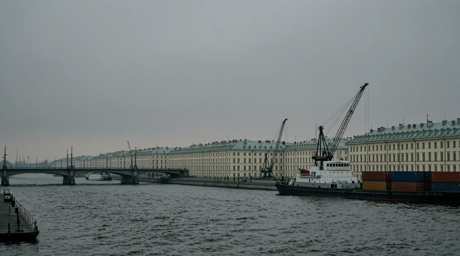 The Neva river in St Petersburg at dusk, with distant rooftops and a low grey sky.