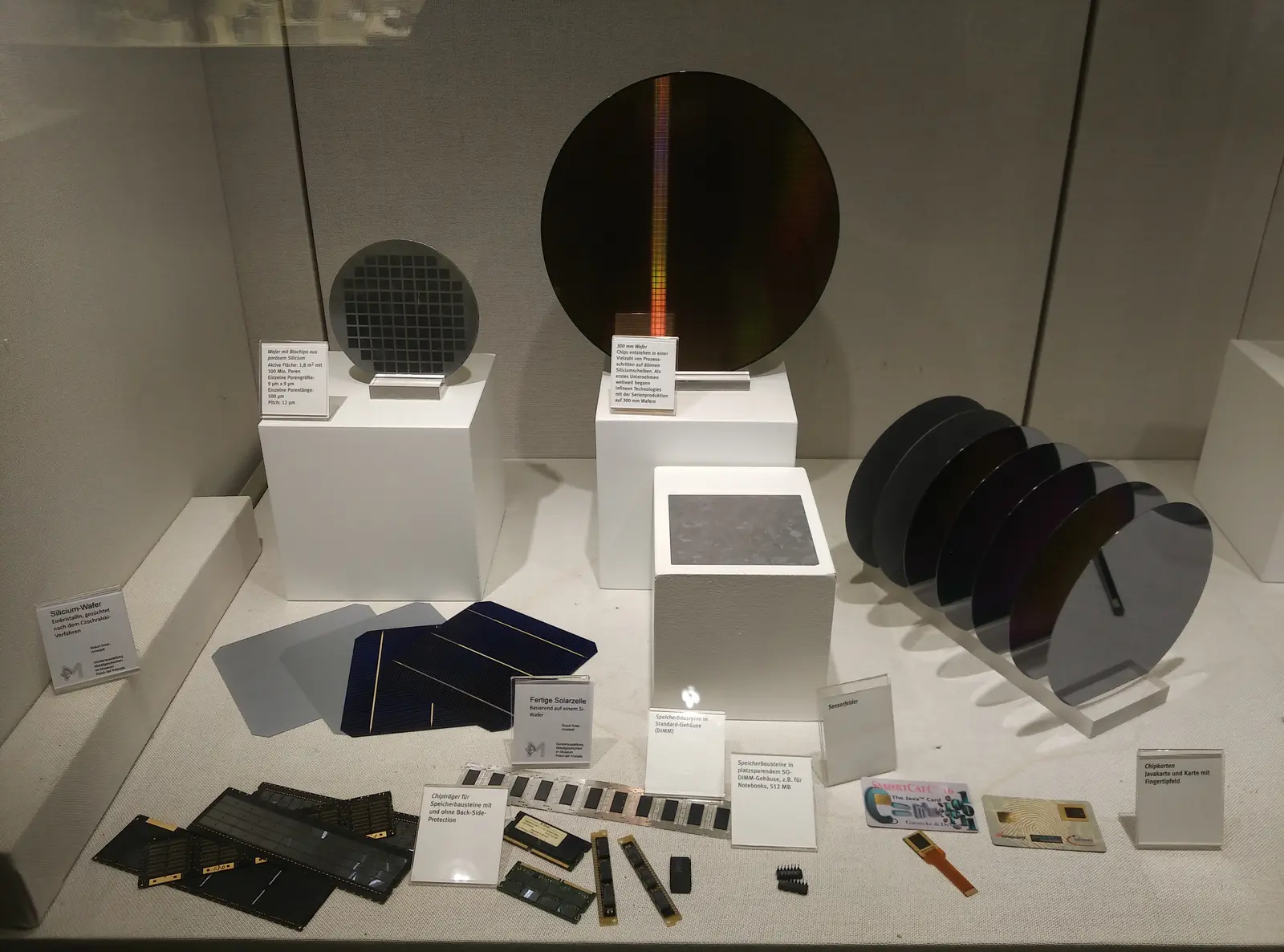 A display case containing various silicon wafers and semiconductor components.
